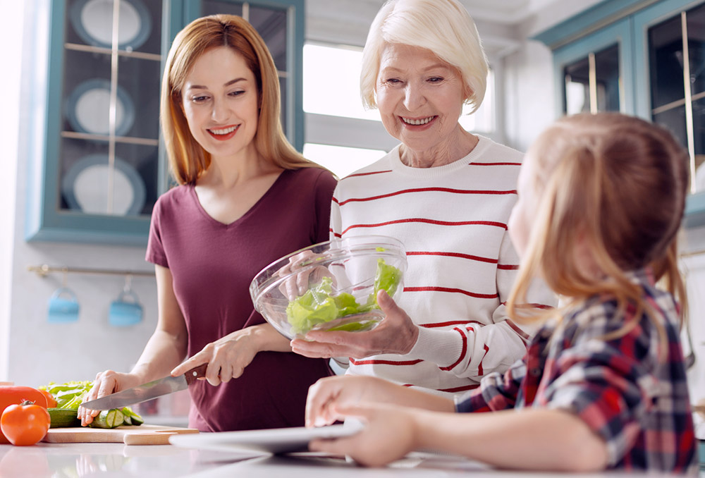 Aide à la préparation des repas avec une personne âgée et sa petite fille